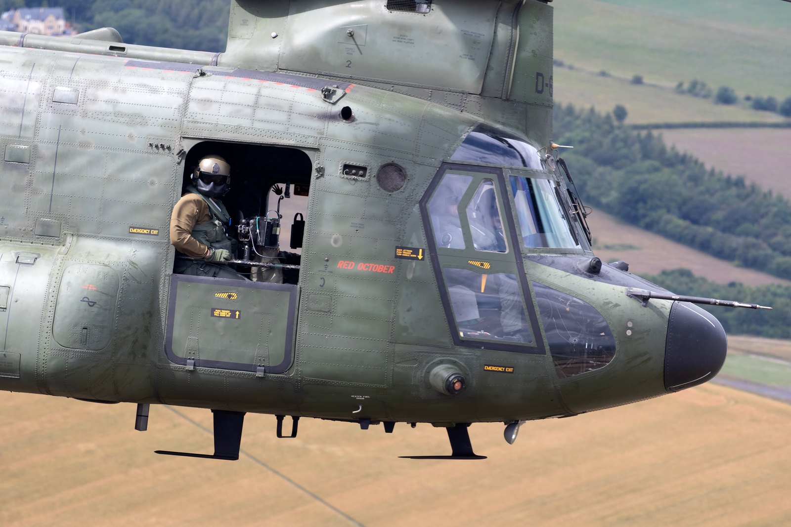 Close-up of the nose of a Royal Netherlands Air Force Chinook named Red October, with a crewman in the open door and a gun on a mount