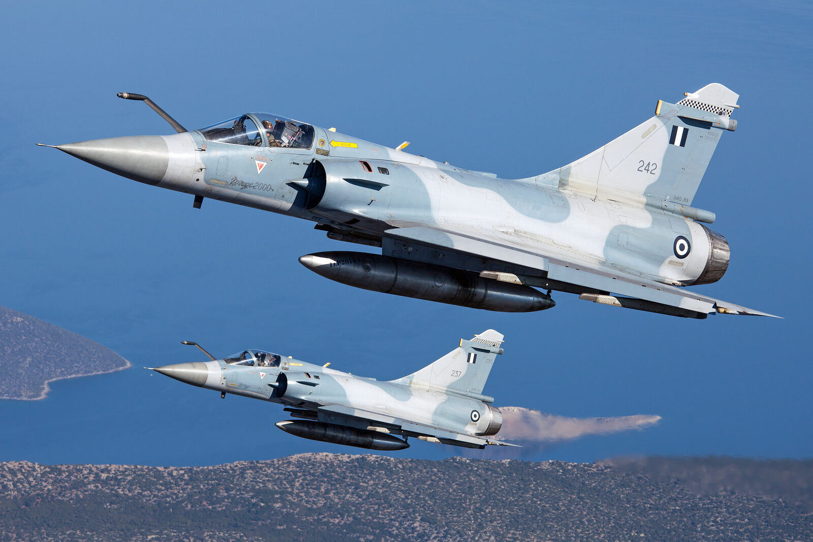 Two Hellenic Air Force Dassault Mirage 2000EG fighters, serials 242 and 237, in formation over the Greek coast