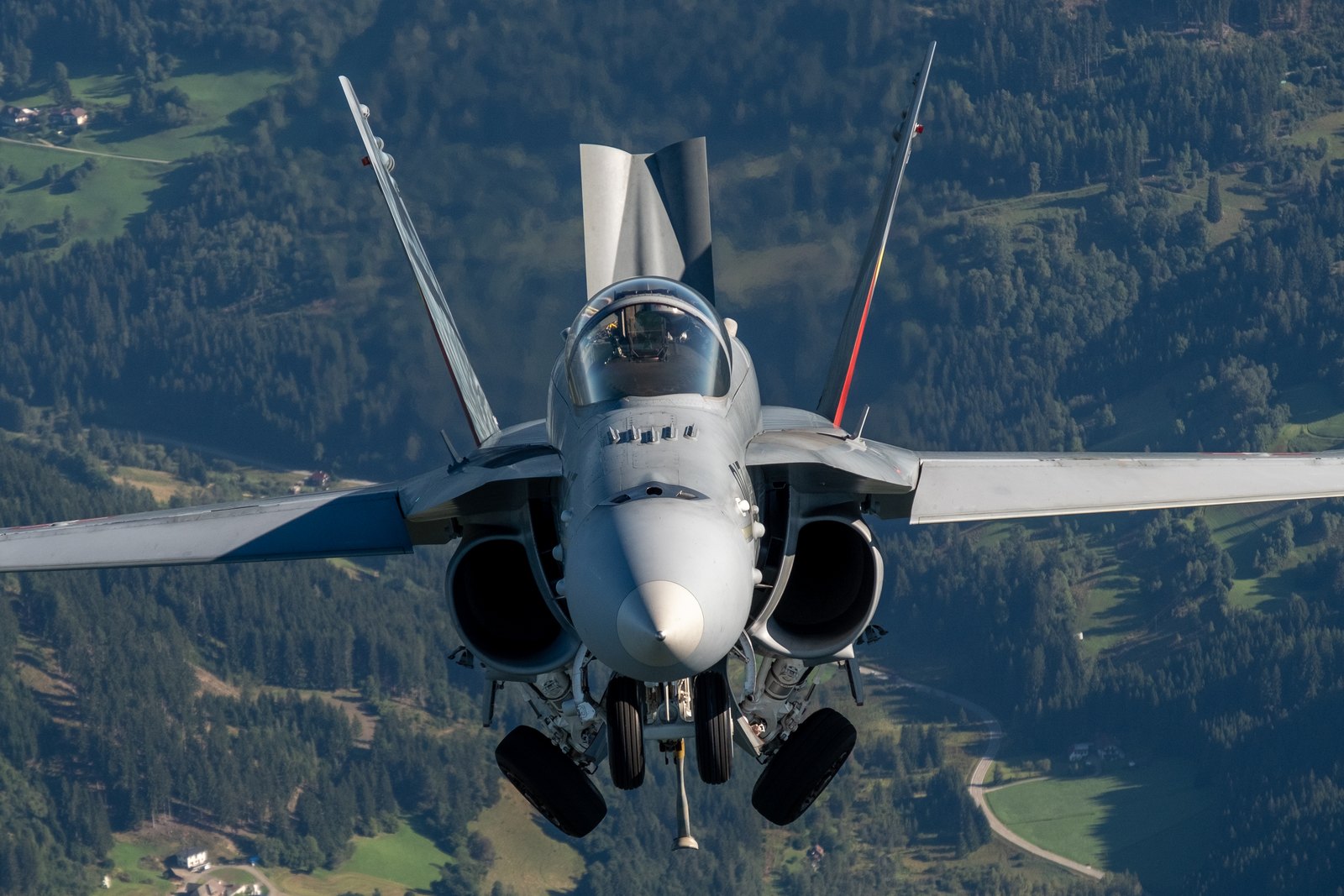 A Swiss Air Force F/A-18C Hornet with its undercarriage down, seen head on over a valley in Austria