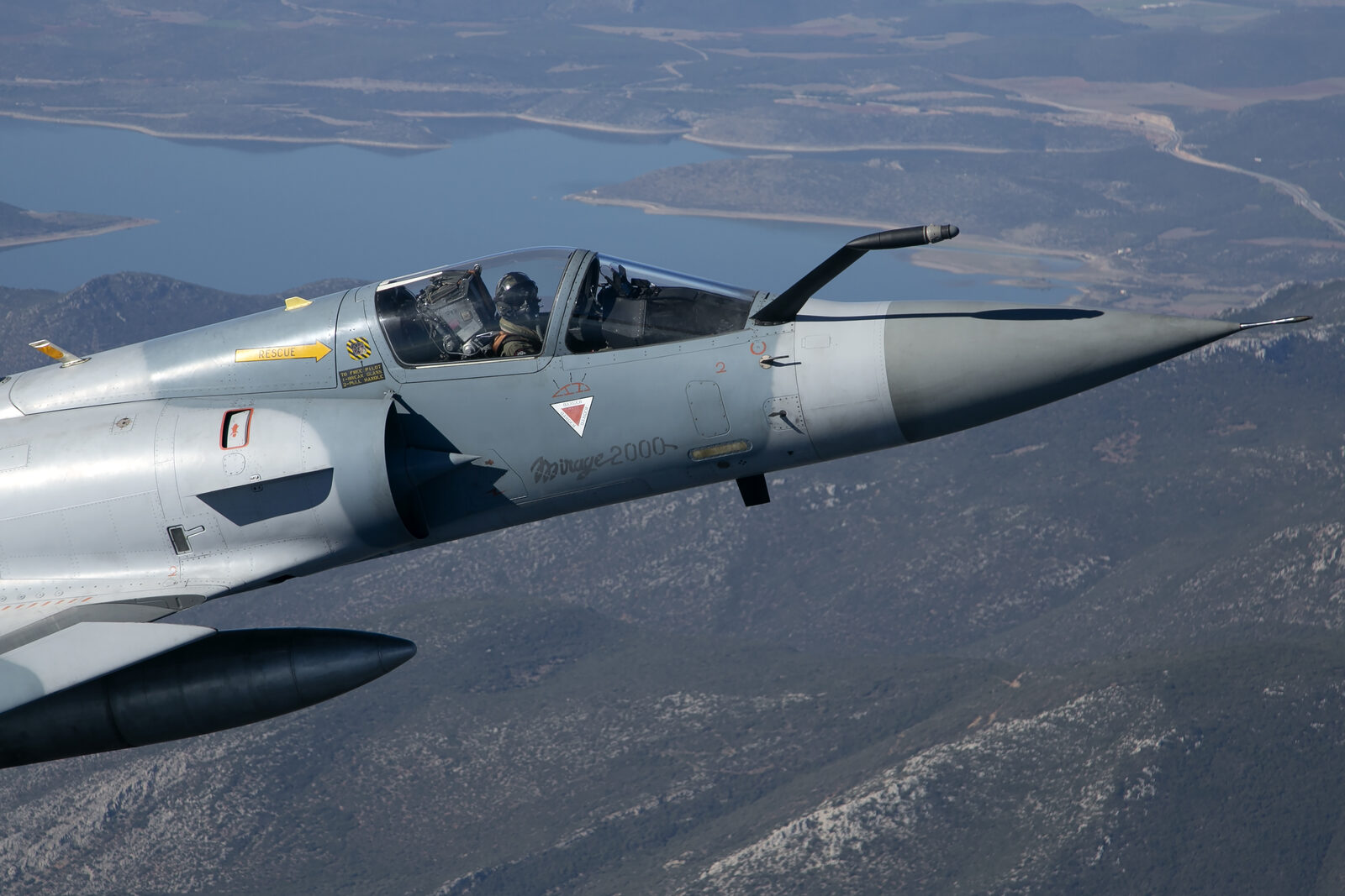 Close-up of the nose of a Hellenic Air Force Dassault Mirage 2000EG showing the fixed refuelling probe, intake half cone and pilot